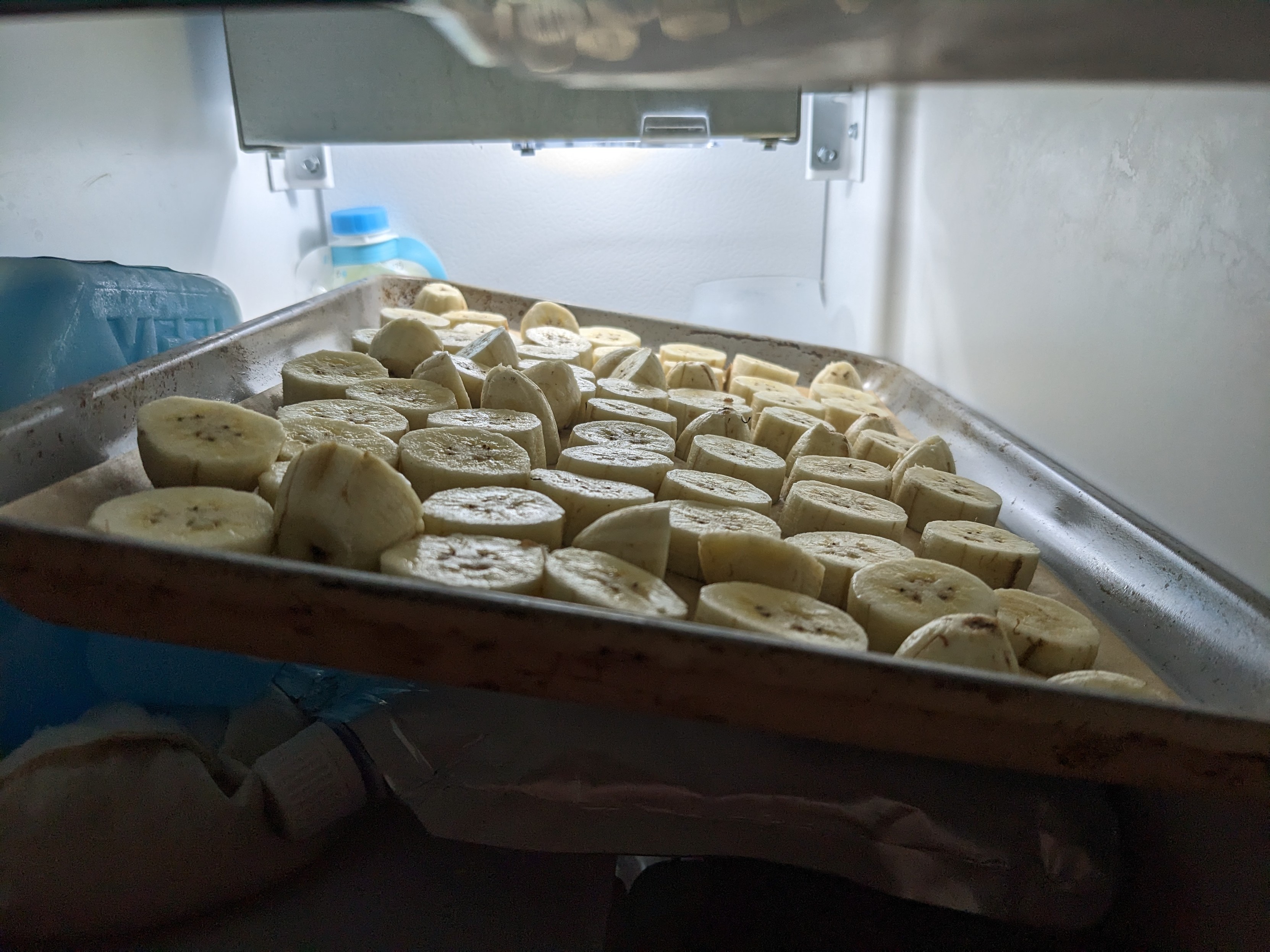 A tray of sliced bananas in the freezer
